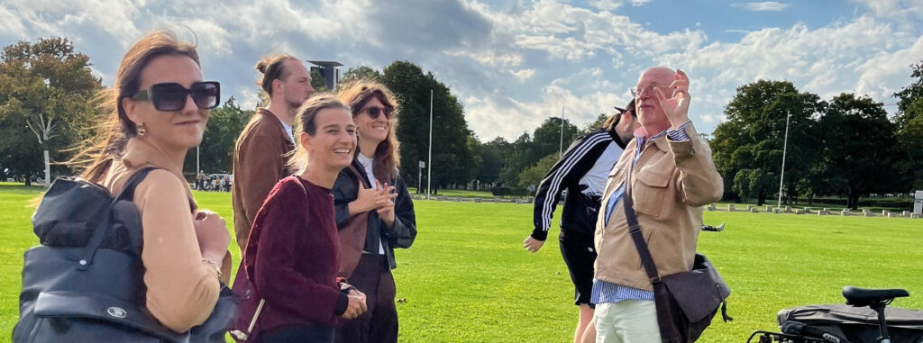 Rondleiding in Berlijn, Martin Boose met een groep op een grasveld